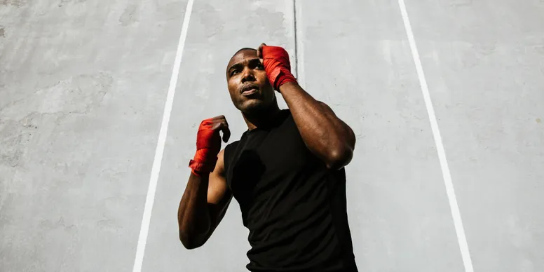 Boxer training with red hand wraps